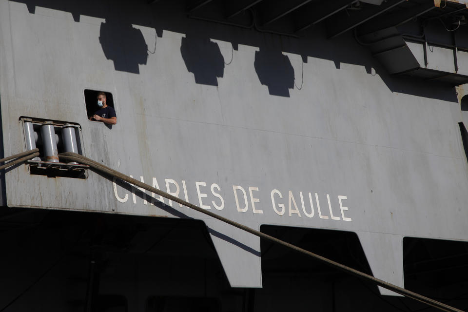 A French crew member is seen of a window at France's nuclear-powered aircraft carrier Charles de Gaulle at Limassol port, Cyprus, Monday, May 10, 2021. With the Task Force's deployment on its mission named "Clemenceau 21," France is assisting in the fight against terrorism while projecting its military power in regions where it has vital interests. (AP Photo/Petros Karadjias)