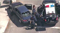 <p>Los Angeles Police officers remove a woman passenger from a car that crashed after a pursuit, and the driver ran into a nearby Trader Joe’s supermarket, starting a hostage situation in the Silverlake district of Los Angeles on Saturday. (Photo: KNBC-TV via AP) </p>