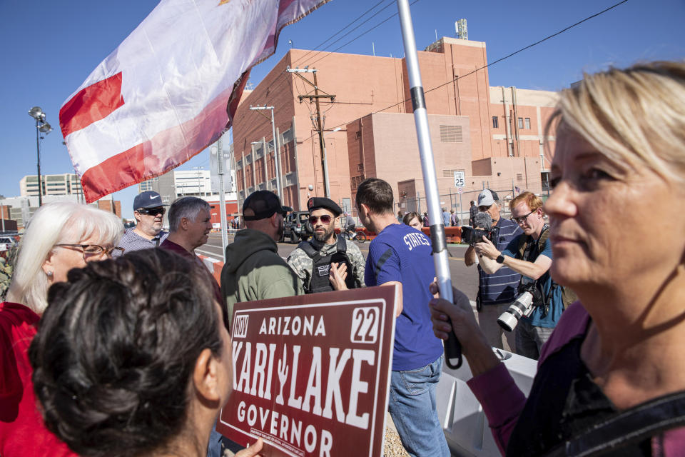 Republican supporters stand outside the Maricopa County Recorder's Office to protest what they allege is an unfair election in Phoenix, Saturday, Nov. 12, 2022. Democratic Sen. Mark Kelly urged Arizonans to let go of “conspiracies of the past” on Saturday, calling for unity a day after he won re-election to a crucial Senate seat. (AP Photo/Alberto Mariani)