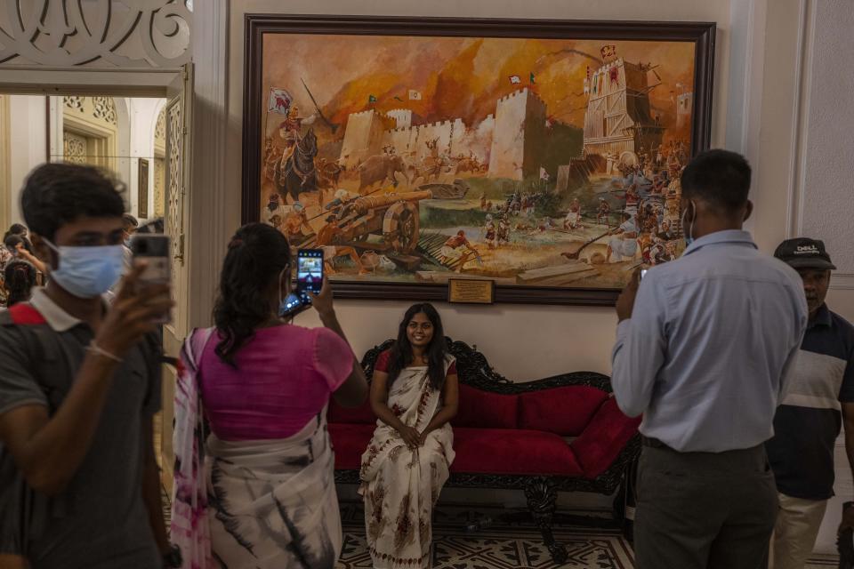 People take pictures at President Gotabaya Rajapaksa's official residence on the second day after it was stormed in Colombo, Sri Lanka, Monday, July 11, 2022. Sri Lanka is in a political vacuum for a second day Monday with opposition leaders yet to agree on who should replace its roundly rejected leaders, whose residences are occupied by protesters, angry over the country's economic woes. (AP Photo/Rafiq Maqbool)