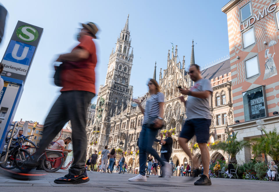 21 September 2020, Bavaria, Munich: Passers-by walk across the Marienplatz in the heart of the Bavarian capital past the town hall. In order to contain the corona virus, the city of Munich wants to make masks mandatory in certain public places and streets in the city centre - if the number of new infections remains at a high level. Photo: Peter Kneffel/dpa (Photo by Peter Kneffel/picture alliance via Getty Images)