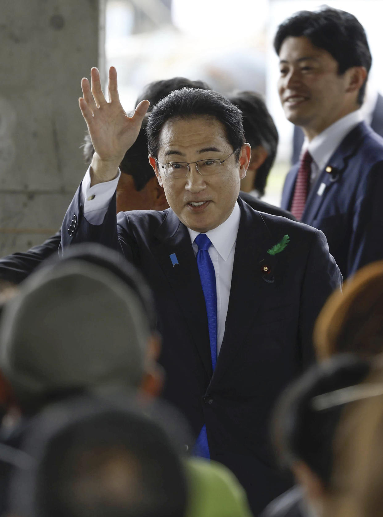 Japanese Prime Minister Fumio Kishida waves as he visits a port in Wakayama, western Japan to cheer his ruling party's candidate in a local election, Saturday, April 15, 2023. Japan’s NHK television reported Saturday that a loud explosion occurred at the western Japanese port during Kishida’s visit, but there were no injuries. (Kyodo News via AP)