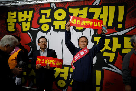 Taxi drivers take part in a protest against a carpool service application that will be launched by Kakao Corp later this year, in central Seoul, South Korea, October 18, 2018. The banners read, "Stop carpool service application, it is illegal business". REUTERS/Kim Hong-Ji