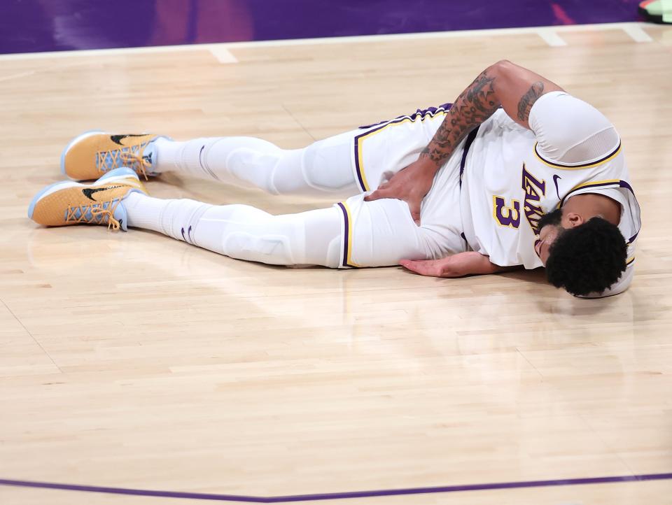 Anthony Davis #3 of the Los Angeles Lakers grabs his thigh after falling during the first half of Game Four of the Western Conference first-round playoff series against the Phoenix Suns at Staples Center on May 30, 2021 in Los Angeles, California.