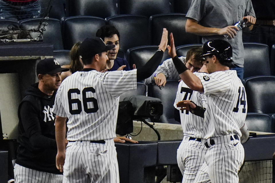 New York Yankees' Tyler Wade (14) celebrates with teammates after scoring on a sacrifice fly ball by Aaron Judge during the fifth inning of the second game of a baseball doubleheader Thursday, May 27, 2021, in New York. The Yankees won 5-3. (AP Photo/Frank Franklin II)