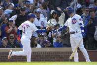 Chicago Cubs' Nick Madrigal, left, is greeted by Nico Hoerner after scoring on Miguel Amaya's pinch-hit single during the eighth inning of a baseball game against the Miami Marlins on Saturday, May 6, 2023, in Chicago. (AP Photo/Charles Rex Arbogast)