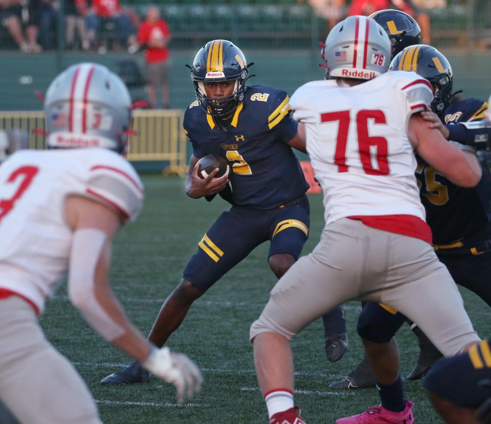 UPrep quarterback Tavion Byrd keeps the ball and cuts upfield for yards in the first quarter.