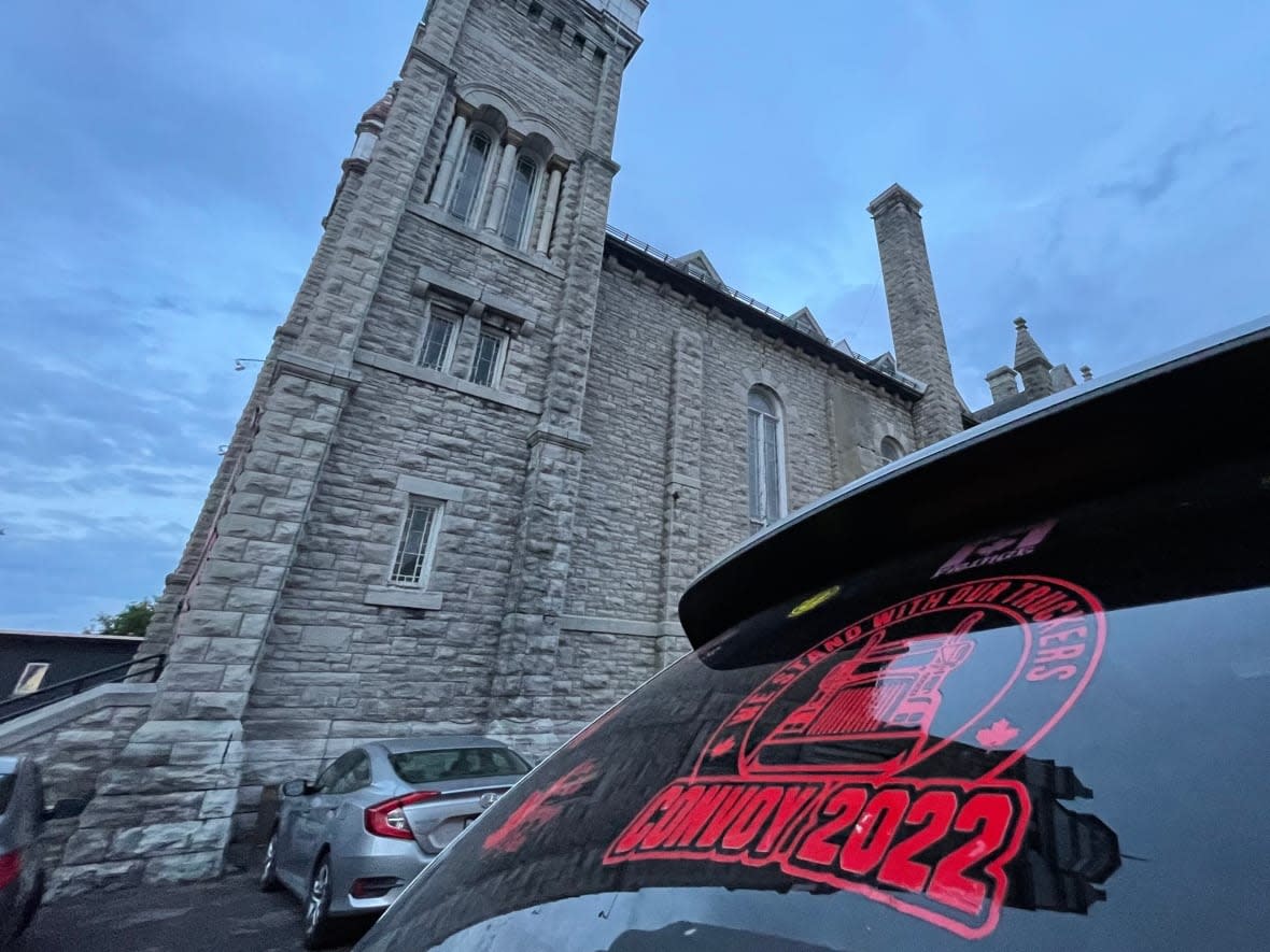 Several vehicles bearing Freedom Convoy-related decals remained in the St. Brigid's Church parking lot Wednesday night after an apparent eviction attempt earlier in the evening. (Falice Chin/CBC - image credit)