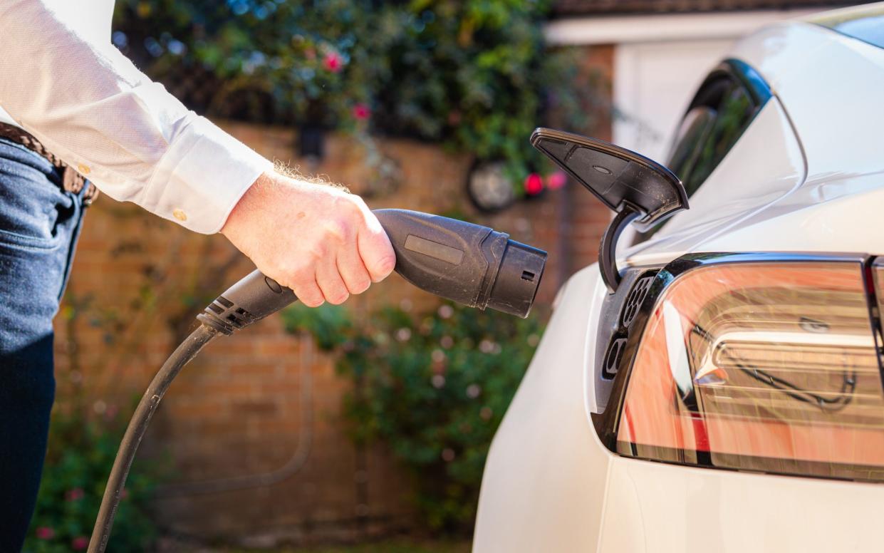 a man charging his electric vehicle at home