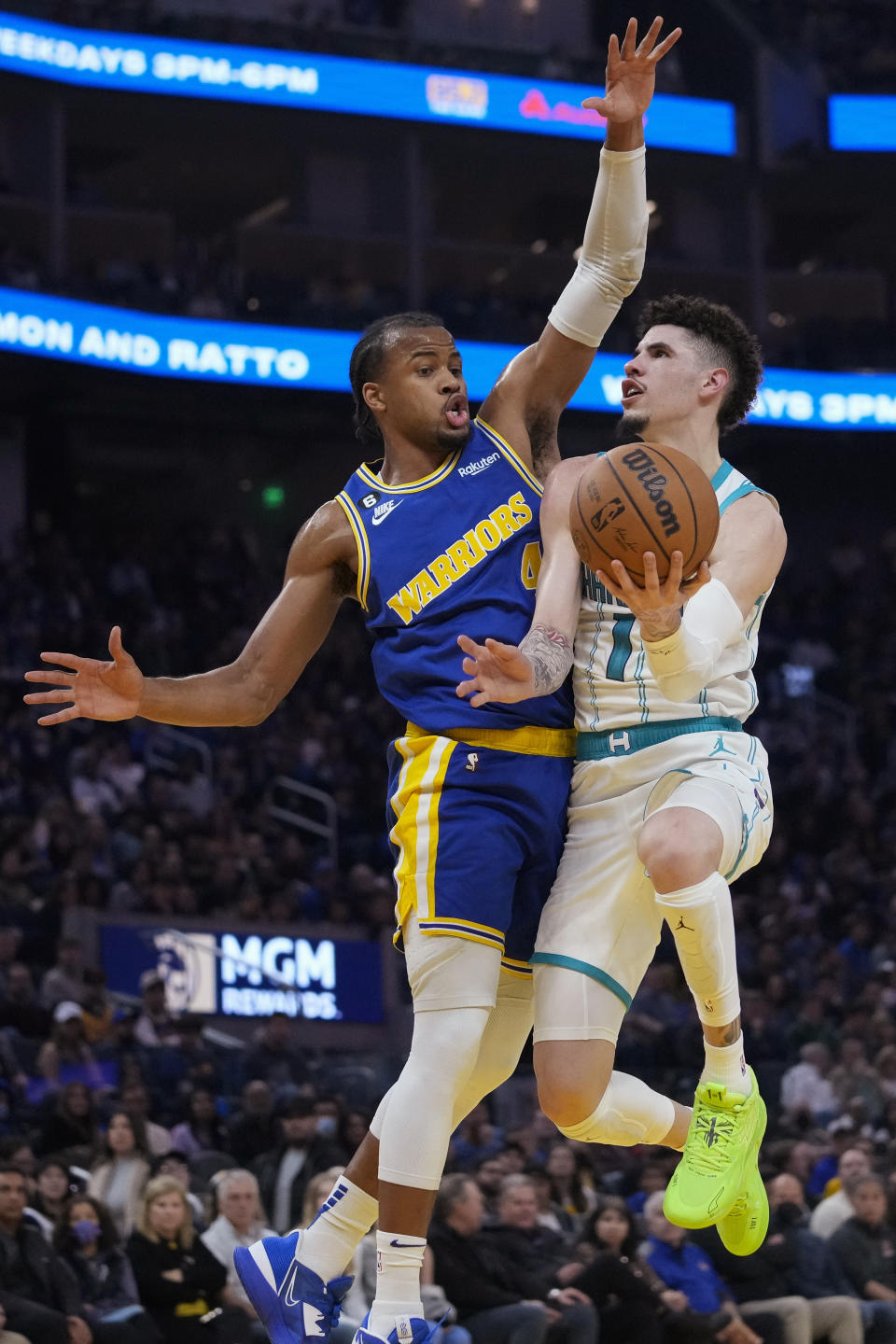 Charlotte Hornets guard LaMelo Ball, right, shoots while defended by Golden State Warriors forward Jonathan Kuminga during the first half of an NBA basketball game in San Francisco, Tuesday, Dec. 27, 2022. (AP Photo/Godofredo A. Vásquez)