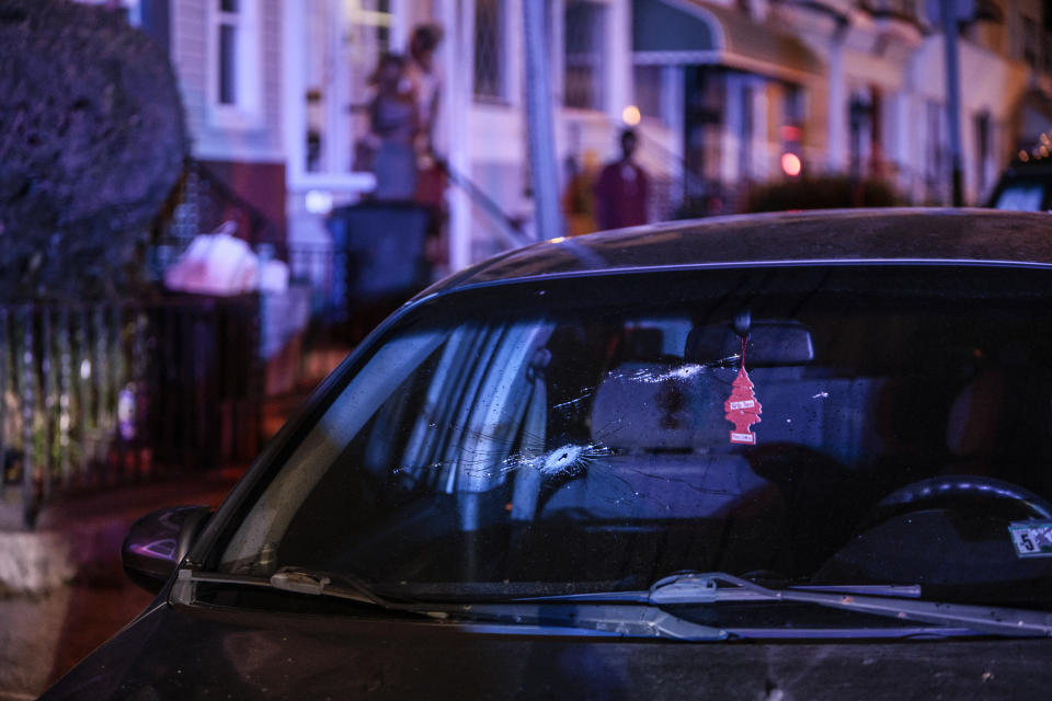 Neighbors look on as police investigate a shooting Monday, July 3, 2023 in Philadelphia. Police say a gunman in a bulletproof vest has opened fire on the streets of Philadelphia, killing several people and wounding two boys before he surrendered to responding officers. (Steven M. Falk/The Philadelphia Inquirer via AP)