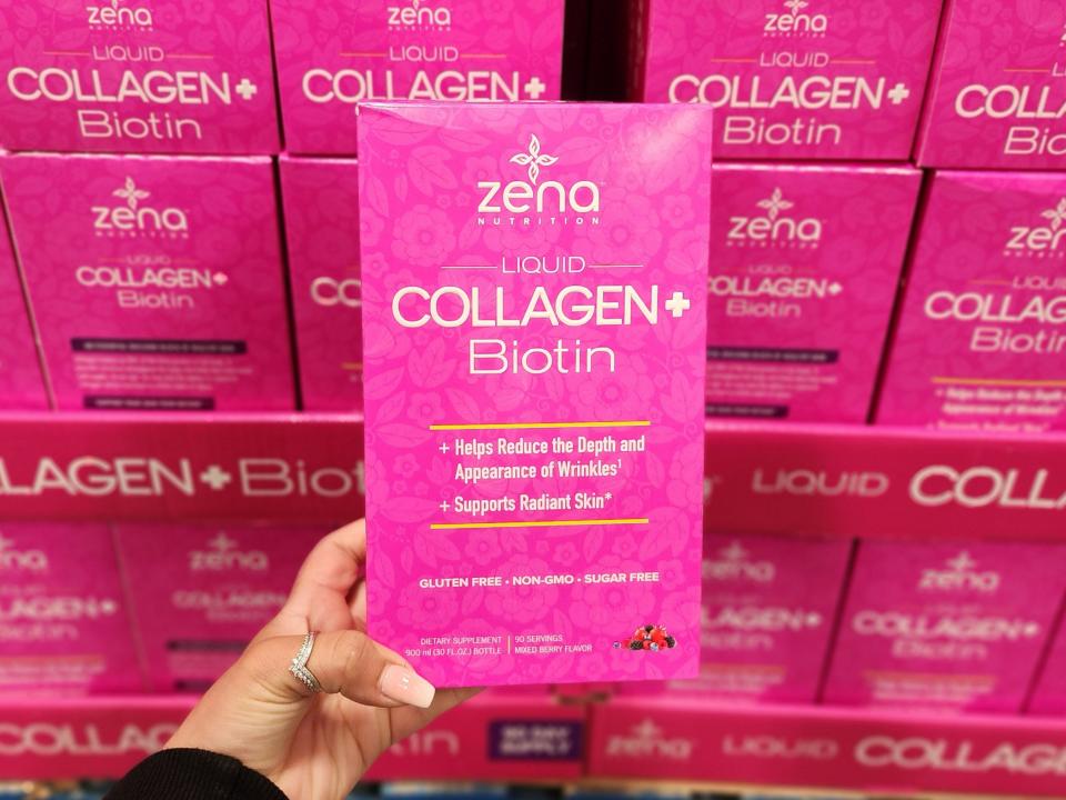 The writer holds a pink box of Zena Nutrition liquid collagen biotin