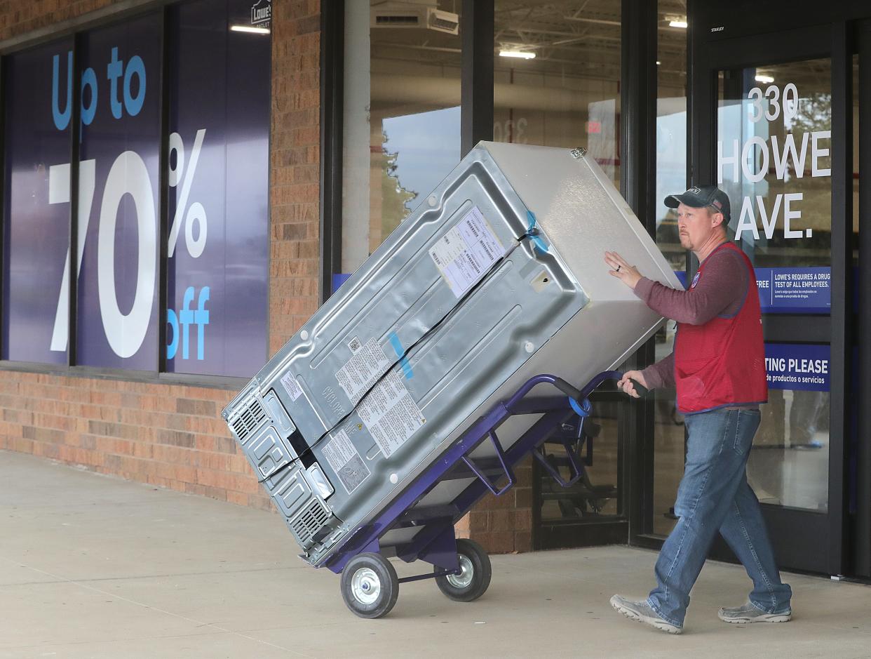 Supervisor Phillip Simpson wheels a refrigerator outside for loading at the new Lowe's Outlet on Tuesday, Oct. 17, 2023, in Cuyahoga Falls, Ohio, in the Chapel Hill Plaza. [Phil Masturzo/ Beacon Journal]
