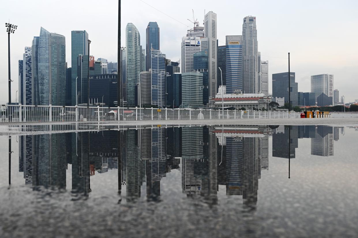 The city skyline is reflected in a pool of rain water at Marina bay in Singapore on October 28, 2020. (Photo by ROSLAN RAHMAN / AFP) (Photo by ROSLAN RAHMAN/AFP via Getty Images)