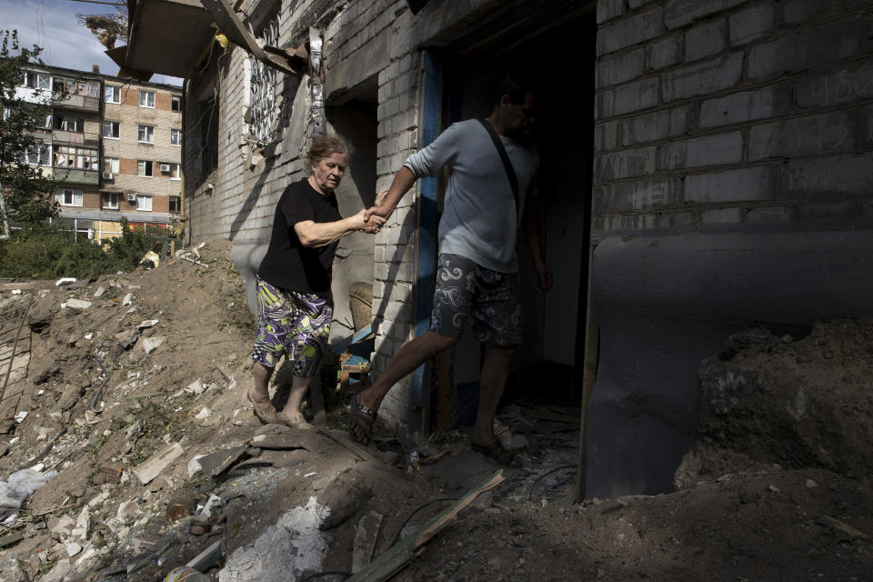 Los residentes analizan los daños a un edificio bombardeado por las fuerzas rusas, que dejó un cráter en el suelo y destruyó varios apartamentos, en Sloviansk, Ucrania, el 25 de agosto de  2022. (Tyler Hicks/The New York Times)