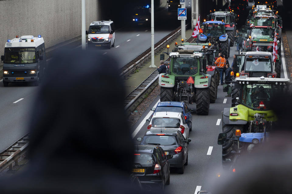 Protesting farmers block a main road leading to the center of The Hague, Netherlands, Wednesday, Oct. 16, 2019. Thousands of Dutch farmers protest over the Netherlands efforts to drastically reduce emissions of greenhouse gases. Among the farmers' demands are that the government does not further reduce the number of animals they can keep. (AP Photo/Peter Dejong)