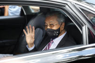 Malaysia's former Prime Minister Mahathir Mohamad waves as he leaves national palace in Kuala Lumpur, Malaysia, Tuesday, April 20, 2021. Malaysian opposition lawmakers, led by Mahathir, submitted a petition to the country's king on Tuesday seeking an end to a coronavirus emergency so Parliament can resume. (AP Photo/FL Wong)