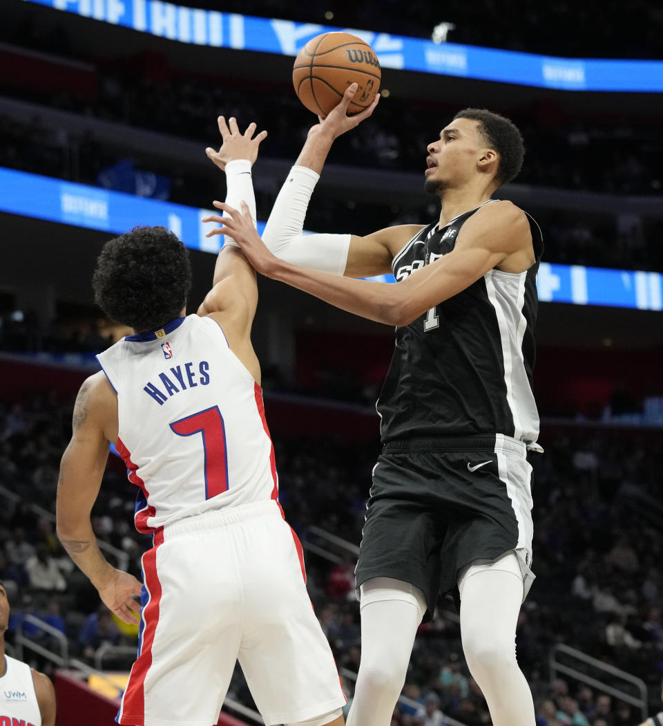 San Antonio Spurs center Victor Wembanyama (1) shoots over the defense of Detroit Pistons guard Killian Hayes (7) during the first half of an NBA basketball game, Wednesday, Jan. 10, 2024, in Detroit. (AP Photo/Carlos Osorio)