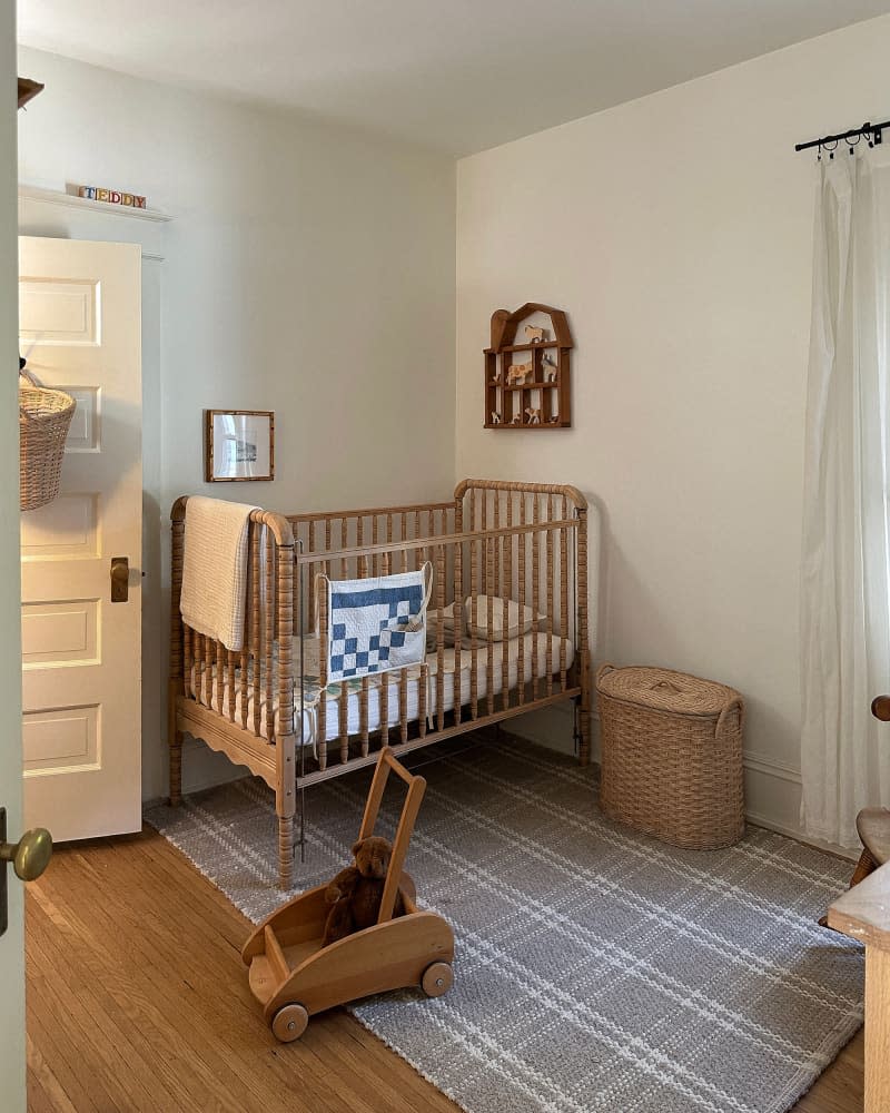 Wooden crib in neutral nursery.