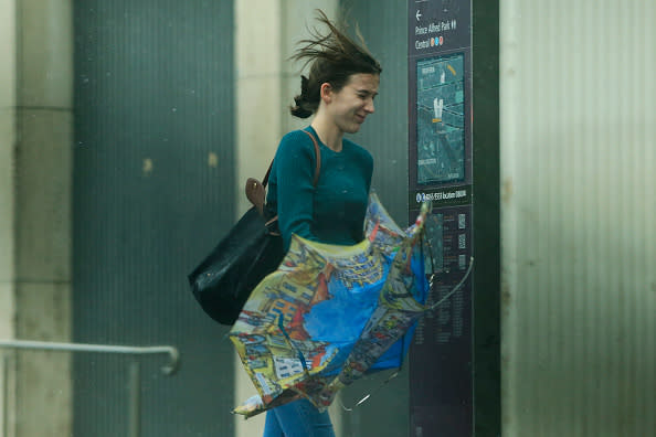 A woman struggles with the wind and rain in Sydney, Australia. 