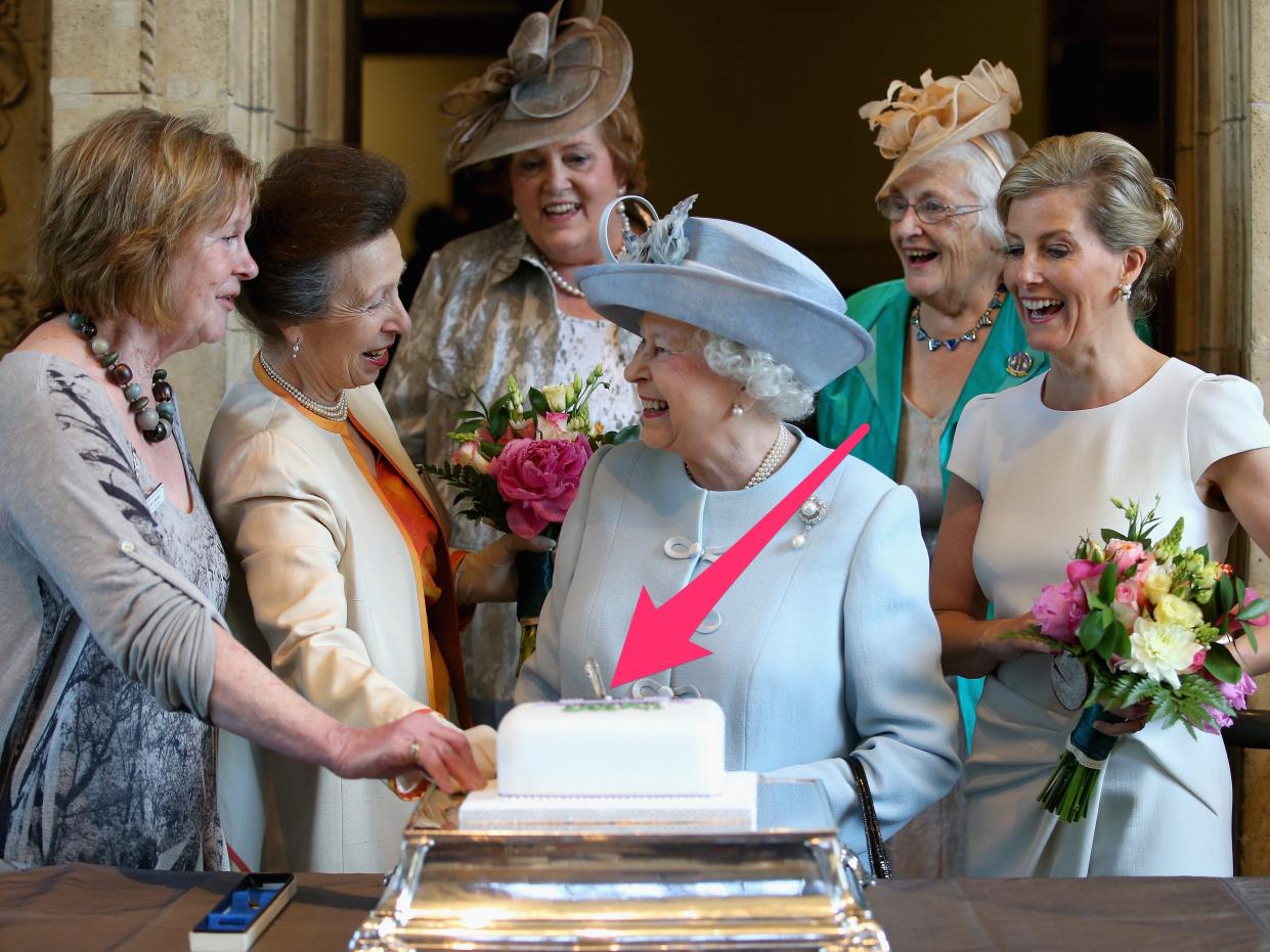 An arrow indicating a knife stuck in a cake that Queen Elizabeth was cutting