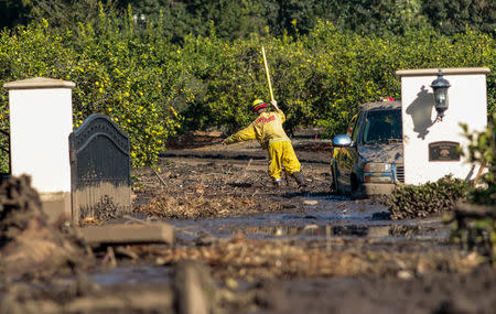 A rescue worker searches through deep mud after a mudslide in Montecito. REUTERS/ Kyle Grillot