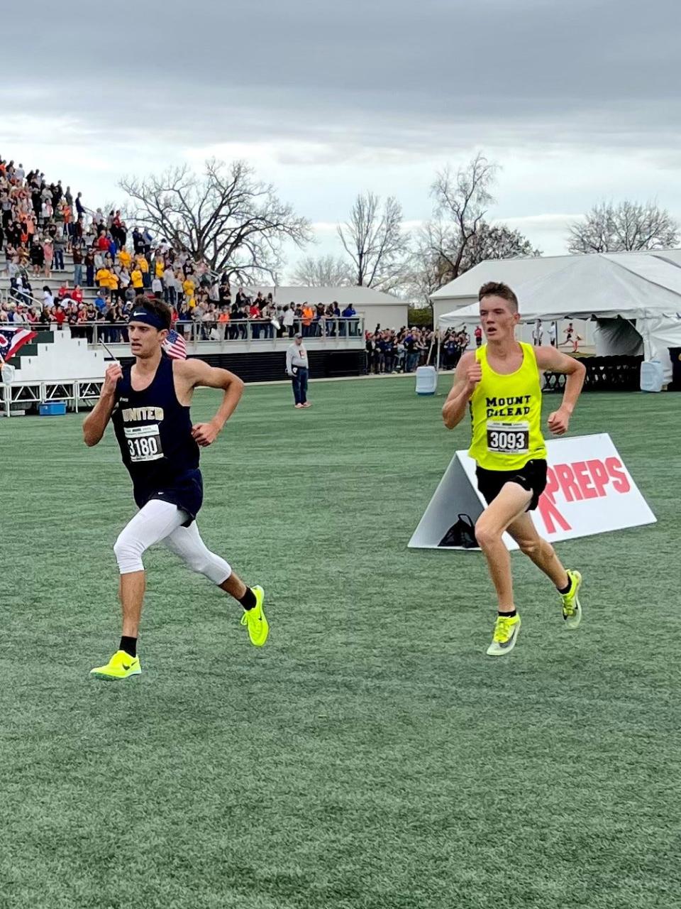 Mount Gilead's Will Baker, right, runs to the finish line during the Division III boys cross country state championship race at Fortress Obetz Saturday morning.