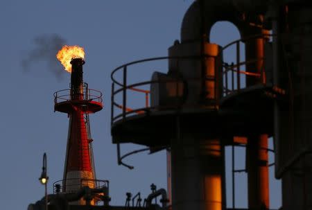 A flame shoots out of a chimney at a petro-industrial factory in Kawasaki near Tokyo December 18, 2014. REUTERS/Thomas Peter/Files