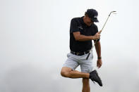 Phil Mickelson cleans his cleats while putting on the 12th hole during a practice round of the U.S. Open Golf Championship Monday, June 14, 2021, at Torrey Pines Golf Course in San Diego. (AP Photo/Gregory Bull)