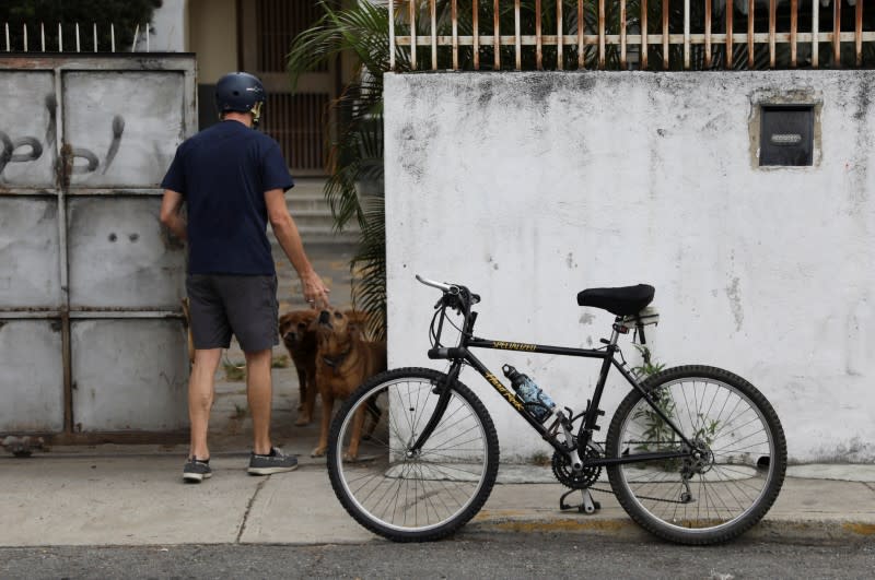 Veterinarian Pedro Villegas arrive at his clinic on his bicycle in Caracas