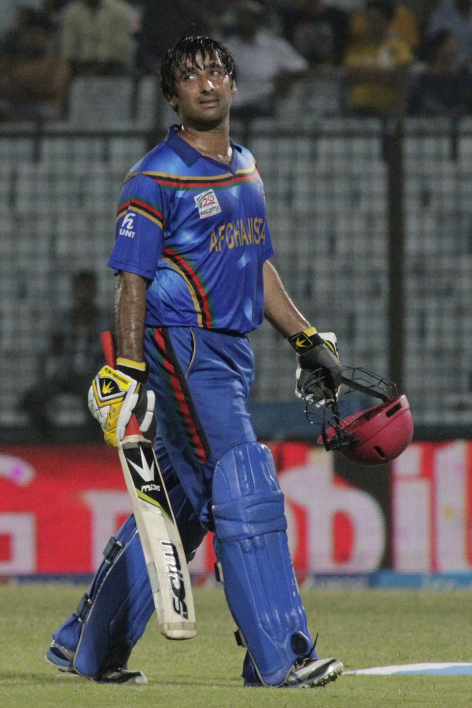 Afghanistan's Asghar Stanikzai watches the replay of his dismissal on a giant screen as he walks out during their ICC Twenty20 Cricket World Cup match against Nepal in Chittagong, Bangladesh, Thursday, March 20, 2014. (AP Photo/Bikas Das)