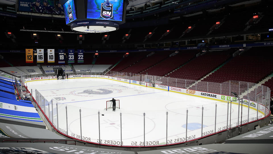 VANCOUVER, BC - MARCH 31: A rink attendant pushes a game net off the ice after the NHL game between the Calgary Flames and the Vancouver Canucks was postponed due to a positive COVID test result of a player at Rogers Arena on March 31, 2021 in Vancouver, British Columbia, Canada.  (Photo by Jeff Vinnick/NHLI via Getty Images)