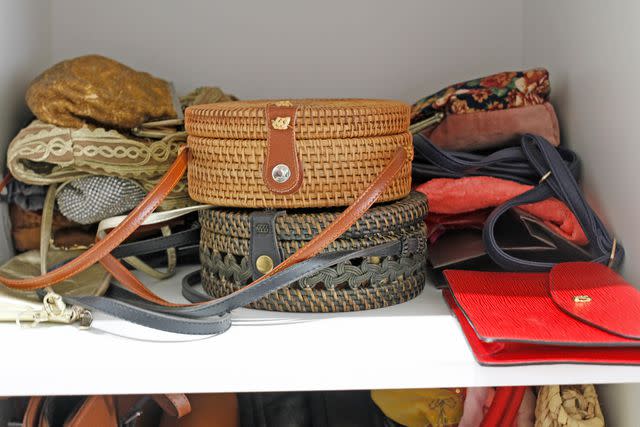 <p>Getty</p> Purses stacked in a closet