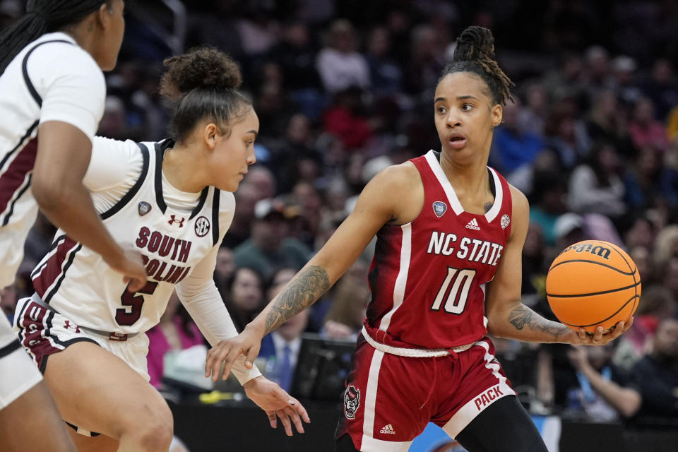 North Carolina State guard Aziaha James (10) drives around South Carolina guard Tessa Johnson (5) during the second half of a Final Four college basketball game in the women's NCAA Tournament, Friday, April 5, 2024, in Cleveland. (AP Photo/Morry Gash)