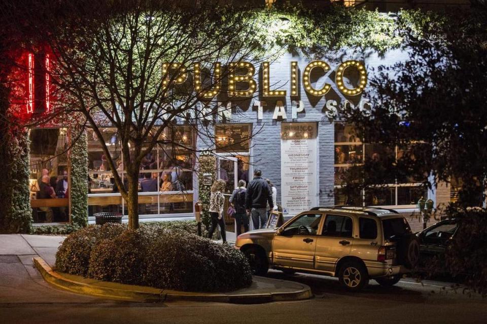 Publico Kitchen and Tap illuminates Greene Street as a crowd begins to fill the restaurant on a recent evening.