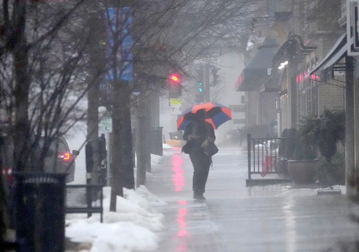 A pedestrian heads through the rain on East Silver Spring Drive in Whitefish Bay on Thursday, Feb. 9, 2023.