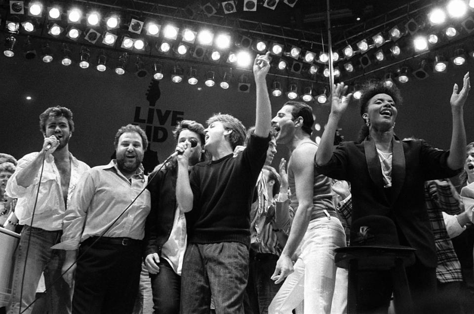 George Michael mit Harvey Goldsmith, U2-Frontmann Bono, Paul McCartney, Bob Geldof und Queen-Sänger Freddie Mercury beim Finale des Live Aid-Konzerts im Wembley Stadium, London am 13. Juli 1985. (Bild: AP Photo/Joe Schaber, File)