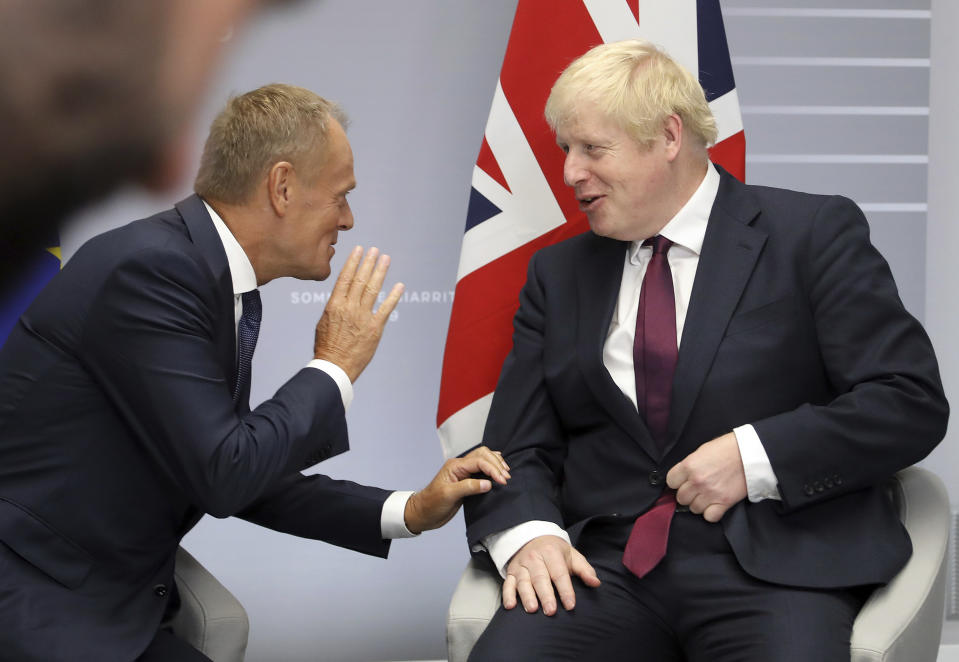 File - In this Sunday, Aug. 25, 2019 file photo, Britain's Prime Minister Boris Johnson, right, and President of the European Council Donald Tusk chat before a meeting on the side of the G-7 summit in Biarritz, France. With negotiations on the UK's departure terms from the EU hanging precariously in the balance at a time when silence seemed golden, both sides broke the spell Tuesday, Oct. 8, 2019 when Tusk directly addressed Johnson on Twitter and gave him his fill about the fast crumbling Brexit negotiations. (AP Photo/Markus Schreiber, File)