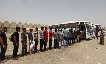 Volunteers, who have joined the Iraqi army to fight against the predominantly Sunni militants from the radical Islamic State of Iraq and the Levant (ISIL) who have taken over Mosul and other northern provinces, prepare to board a bus in Baghdad, June 20, 2014. REUTERS/Ahmed Saad