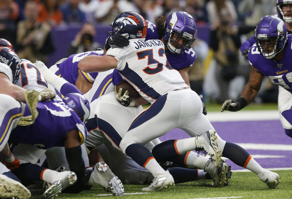 Denver Broncos fullback Andy Janovich (32) scores on a 1-yard touchdown run in front of Minnesota Vikings middle linebacker Eric Kendricks, right, during the first half of an NFL football game, Sunday, Nov. 17, 2019, in Minneapolis. (AP Photo/Jim Mone)