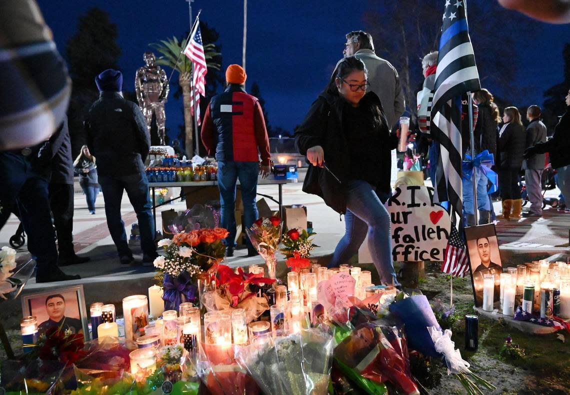 Candles are displayed as a memorial at Veterans Park as the community gathers for a vigil for slain Selma officer Gonzalo Carrasco Jr. Thursday, Feb 2, 2023 in Selma.