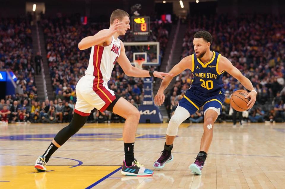 Golden State Warriors guard Stephen Curry (30) dribbles the ball next to Miami Heat forward Nikola Jovic (5) in the second quarter at the Chase Center.
