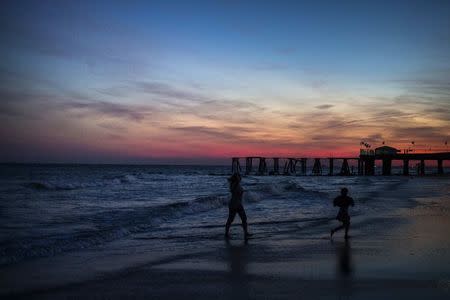 Family members are silhouetted along the beachfront during sunset in Atlantic City, New Jersey September 12, 2014. REUTERS/Adrees Latif