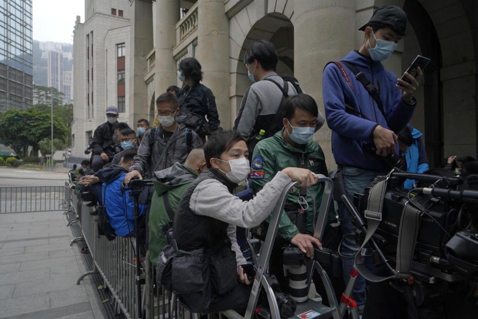 Mike Hui, front left, waits outside the Hong Kong's Court of Final Appeal for the court case of democracy advocate Jimmy Lai who founded the Apple Daily tabloid, in Hong Kong on Feb. 9, 2021. Until early April, Hui was a photojournalist for the Apple Daily, a pro-democracy newspaper that shut down following the arrest of five top editors and executives and the freezing of its assets under a national security law that China's ruling Communist Party imposed on Hong Kong as part of the crackdown. (AP Photo/Kin Cheung)