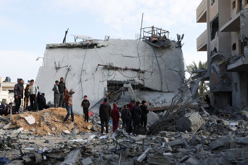 Palestinians gather near a house hit by an Israeli strike, in Rafah in the southern Gaza Strip