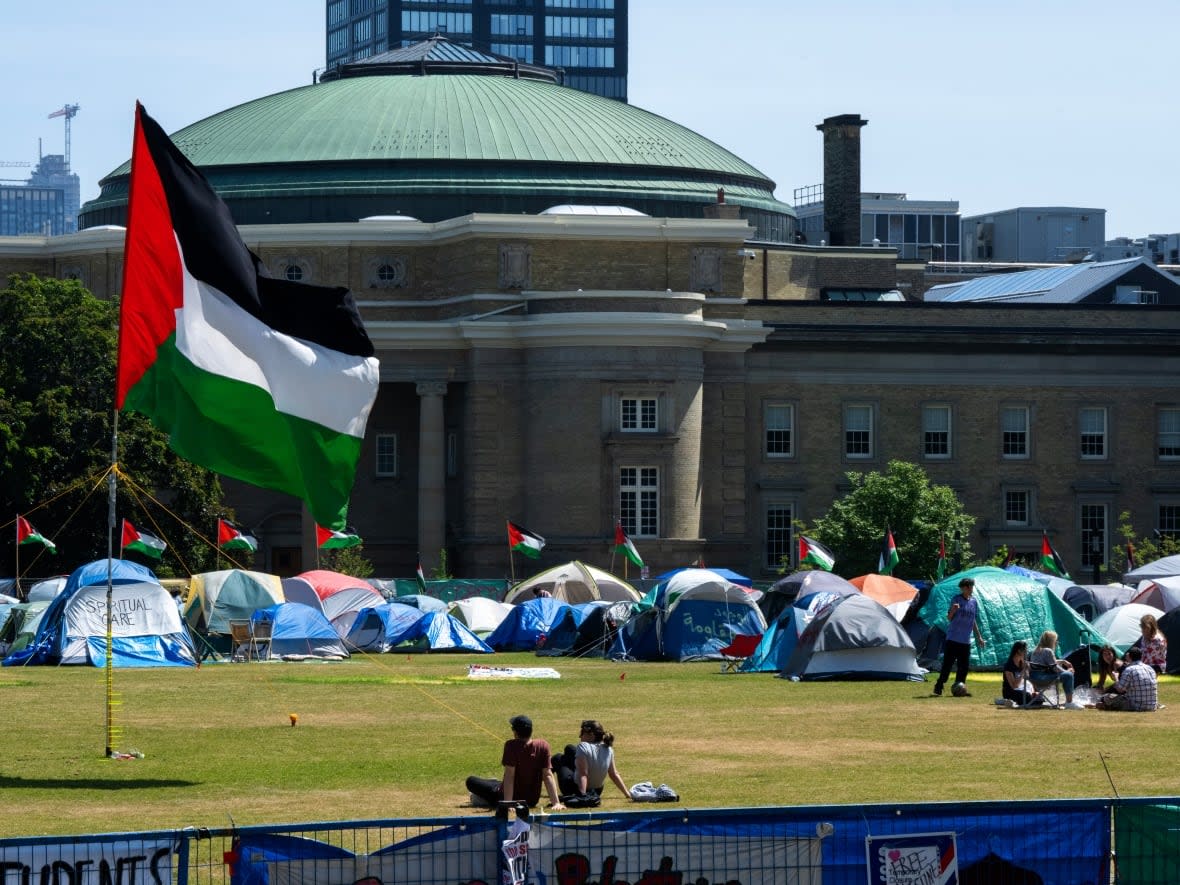 The University of Toronto's Convocation Hall sits directly next to the pro-Palestinian encampment on the school's St. George campus.  (Frank Gunn/The Canadian Press - image credit)