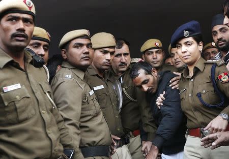 Policemen escort driver Shiv Kumar Yadav (in black jacket) who is accused of a rape outside a court in New Delhi December 8, 2014. REUTERS/Adnan Abidi