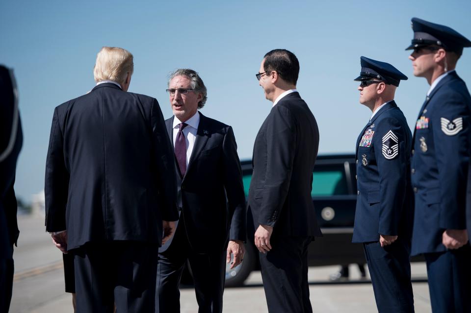 US President Donald Trump (L) and US Secretary of the Treasury Steven Mnuchin (C) talk with North Dakota Governor Doug Burgum (C) after arriving at Bismarck Municipal Airport on September 6, 2017 in Bismarck, North Dakota. / AFP PHOTO / Brendan Smialowski        (Photo credit should read BRENDAN SMIALOWSKI/AFP via Getty Images)