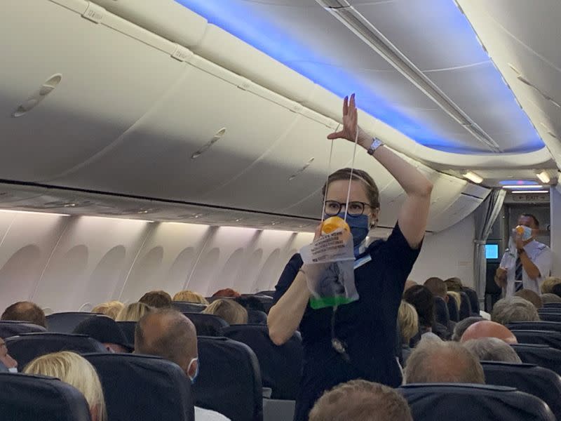 Las azafatas de TUI Fly usan mascarillas mientras dan instrucciones a los turistas alemanes en el primer vuelo de Dusseldorf a Mallorca en Dusseldorf, Alemania, el 15 de junio de 2020