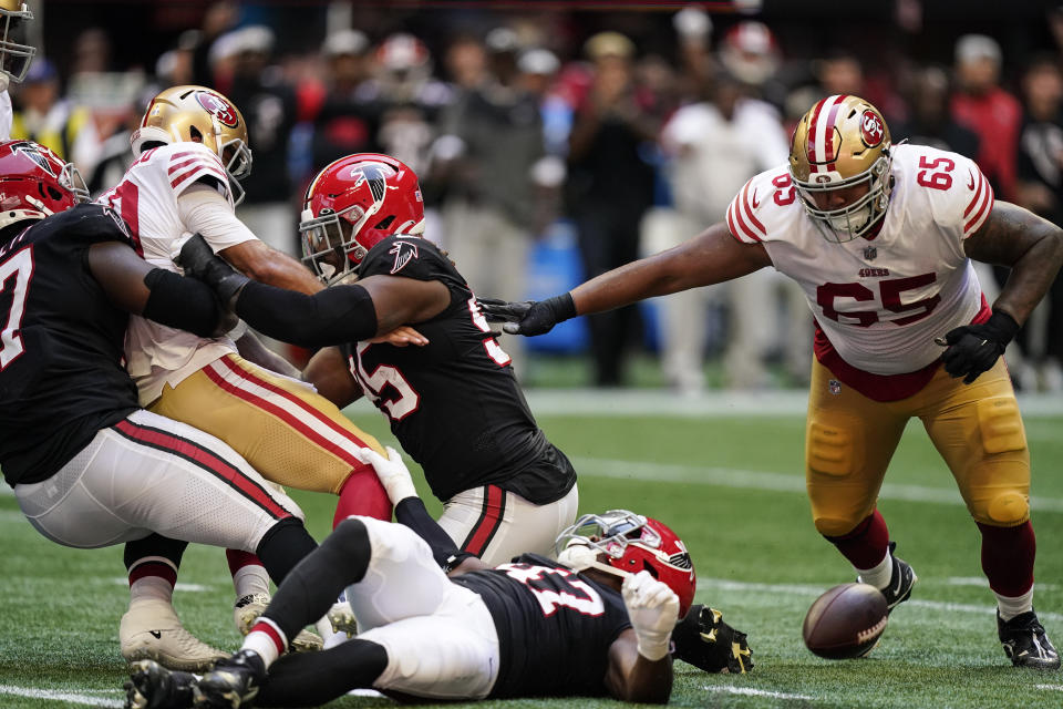 San Francisco 49ers quarterback Jimmy Garoppolo (10) is stripped of the ball by Atlanta Falcons defensive end Grady Jarrett (97) and San Francisco 49ers guard Aaron Banks (65) recovers the fumble during the first half of an NFL football game, Sunday, Oct. 16, 2022, in Atlanta. (AP Photo/Brynn Anderson)